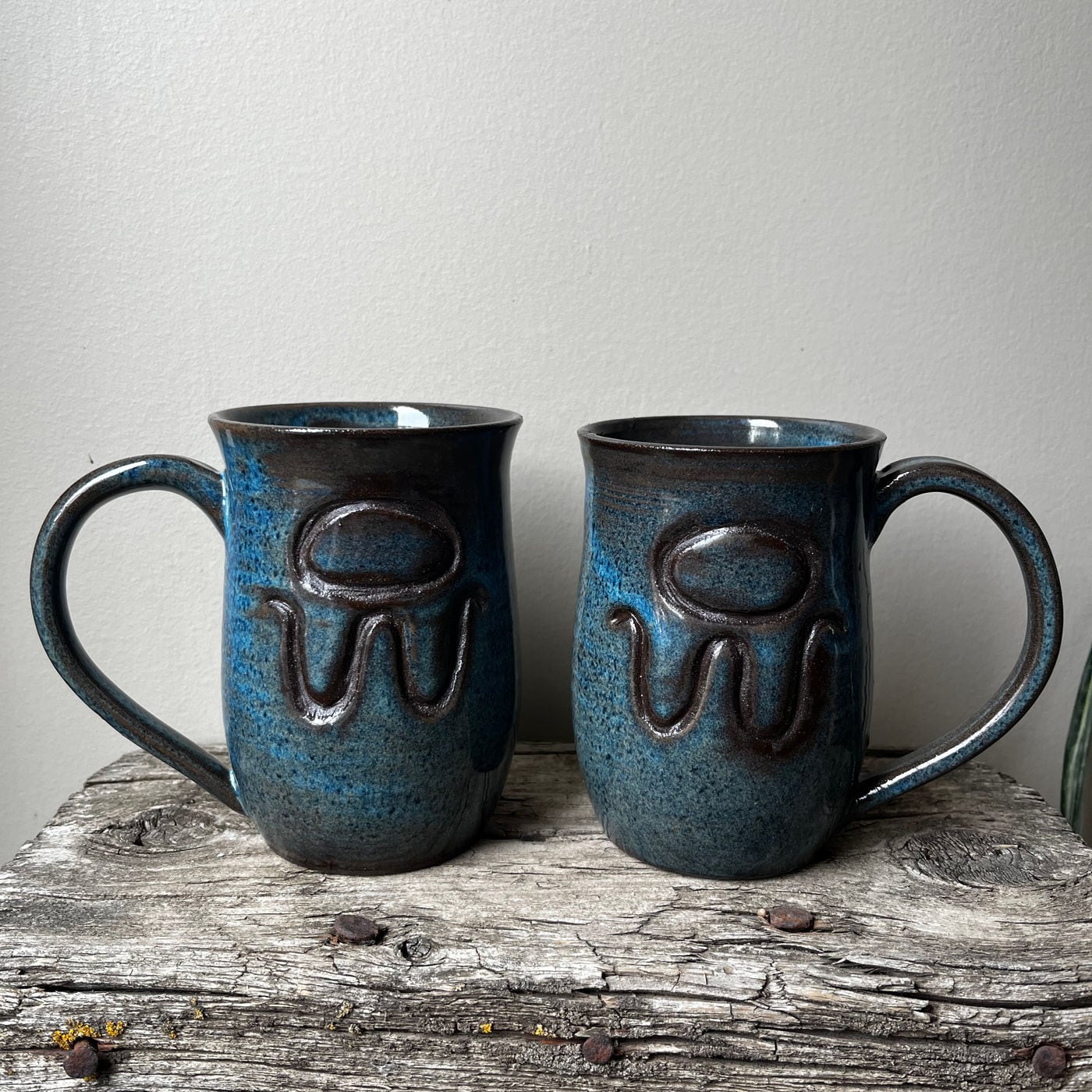 A mug with a cattle brand carved into it by hand